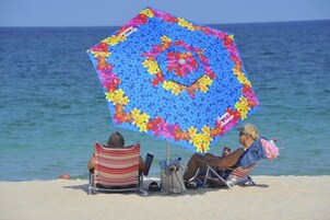 Beach nearby, white sand, beach umbrellas, beach towels