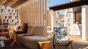 An outdoor seating area with a sofa, a chair, and a table. - Inturotel Esmeralda Garden (Santanyi)
