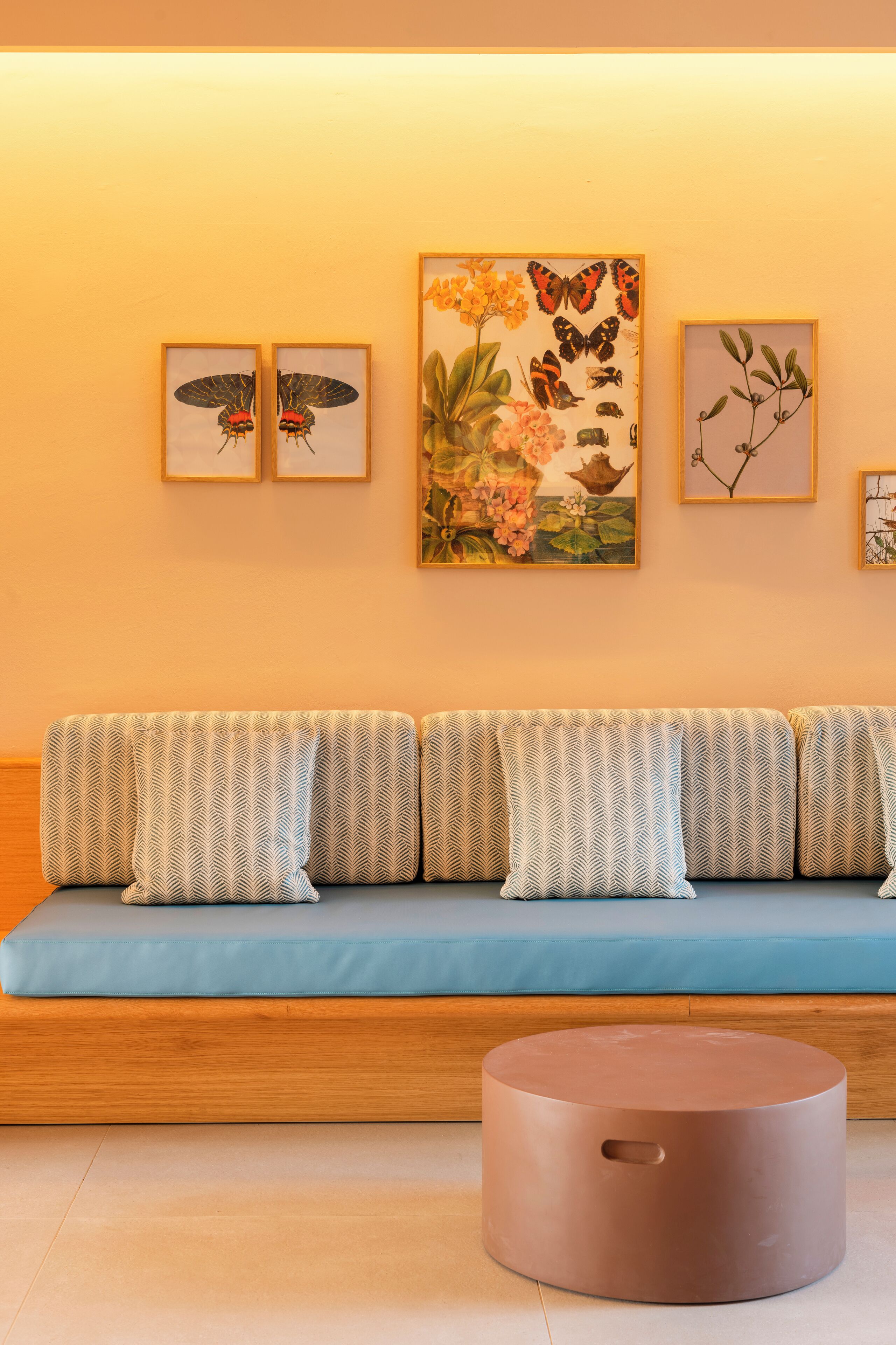 A modern living room with a blue sofa, patterned cushions, and a round coffee table.
