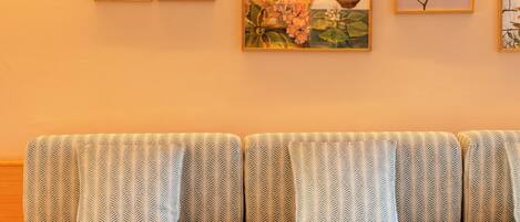 A modern living room with a blue sofa, patterned cushions, and a round coffee table.