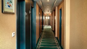 A hotel hallway with a carpeted floor, doors on both sides, and a ceiling with recessed lighting. - GreenTree Inn WenZhou XiaoNanMen Express Hotel (Wenzhou)