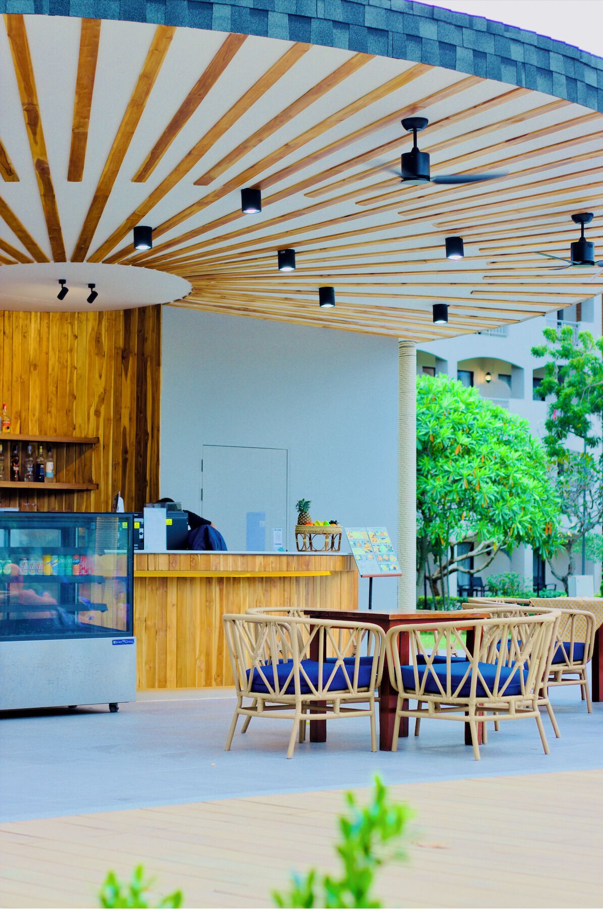 An outdoor seating area with wooden furniture and a wooden ceiling structure.