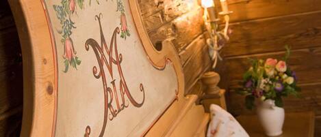 A wooden headboard with a floral design and the initials "M A" carved into it.
