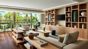 A modern living room with a sofa, coffee table, and shelves with decorative items. - Algarve Marriott Salgados Golf Resort & Spa (Albufeira)