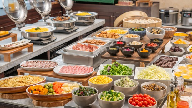 A buffet with various food items including meats, vegetables, and salads.