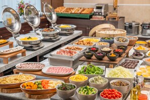 A buffet with various food items including meats, vegetables, and salads.