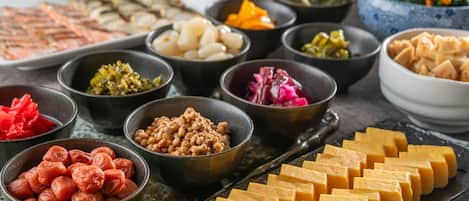 A variety of dishes arranged on a table, including tofu, pickled vegetables, and other food items.