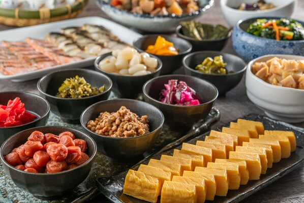 A variety of dishes arranged on a table, including tofu, pickled vegetables, and other food items.