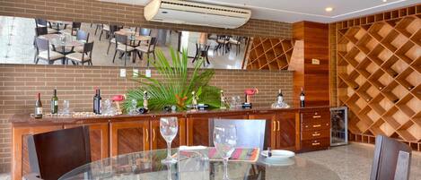 Een restaurant met een glazen tafel, stoelen en een bakstenen muur.