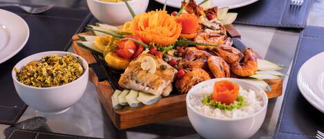 A table set with various dishes including seafood, rice, and vegetables.