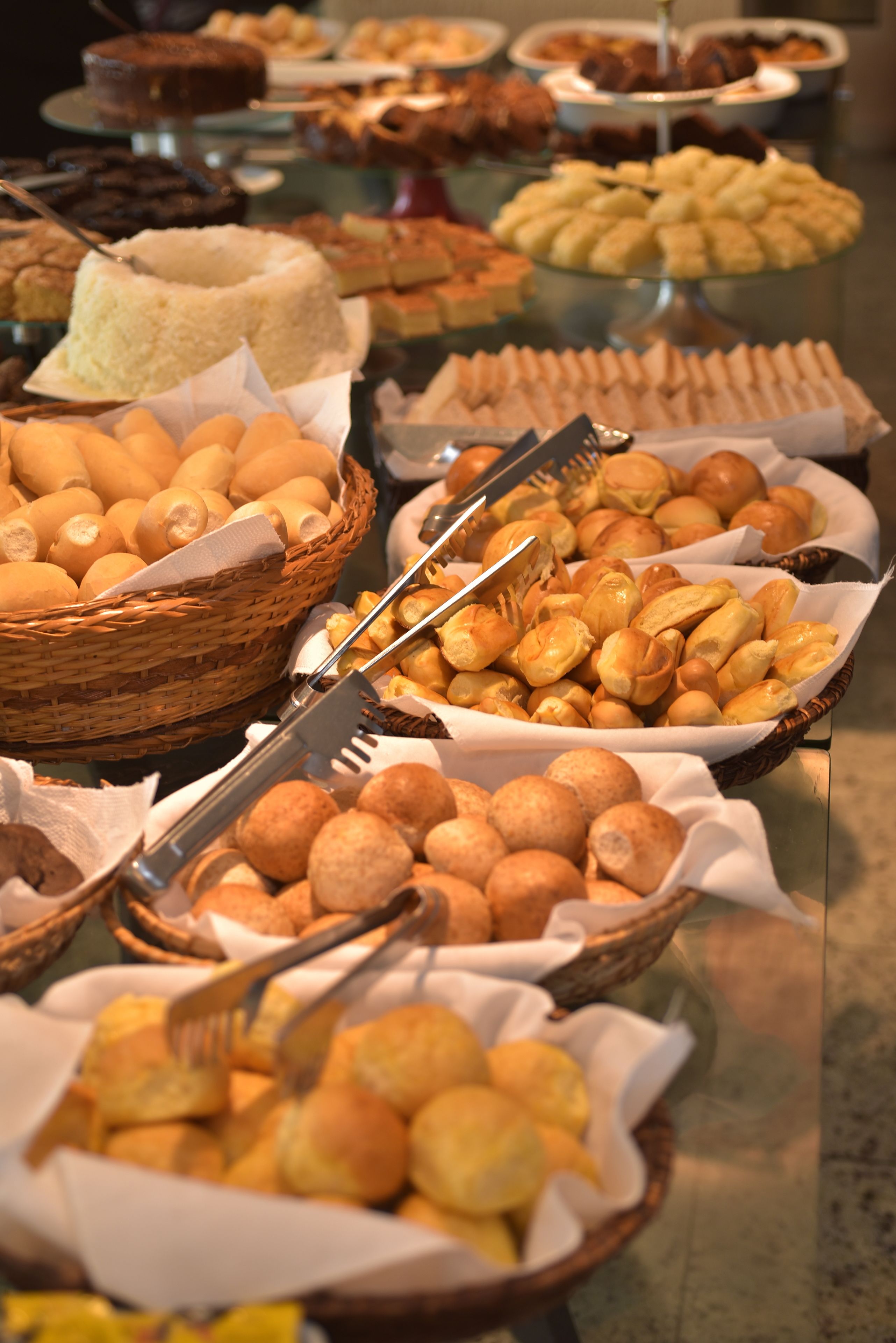 Un bufé con diversas opciones de panadería, incluyendo pan, pasteles y bollos.