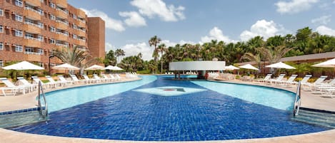 Una piscina al aire libre, sillones reclinables de piscina