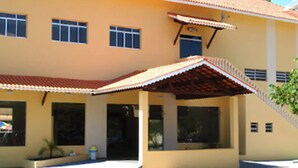 Um edifício de dois andares com telhado plano e varanda coberta.