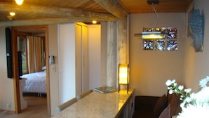 A kitchen with a granite countertop, wooden cabinets, and a hanging light fixture. - Pousada The Goldeneye (Porto Belo)
