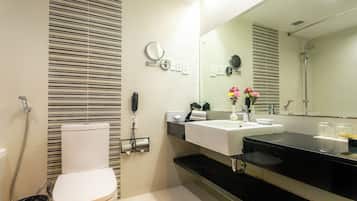 A modern bathroom with a toilet, sink, and shower.