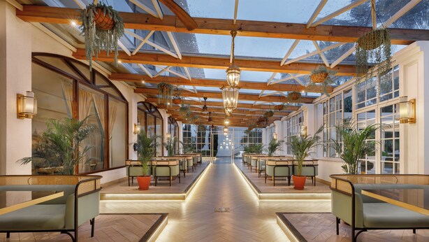 A spacious corridor with wooden beams and glass walls, lined with seating and potted plants. - Hotel Himalaya Kathmandu - Your Business & Leisure Retreat (Lalitpur)