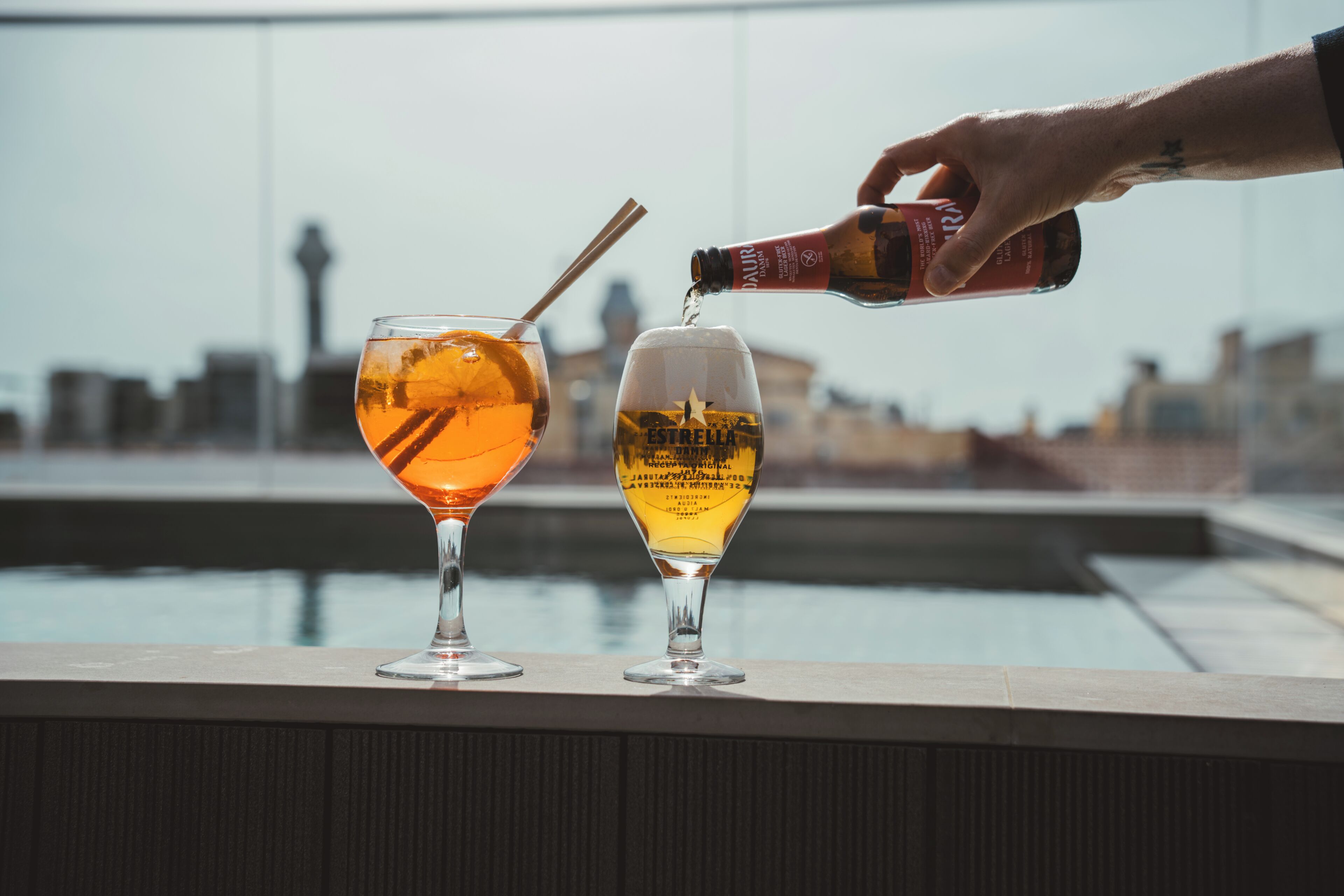 Dos vasos sobre un repisa con un paisaje urbano al fondo.