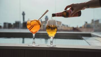 Dos vasos sobre un repisa con un paisaje urbano al fondo.