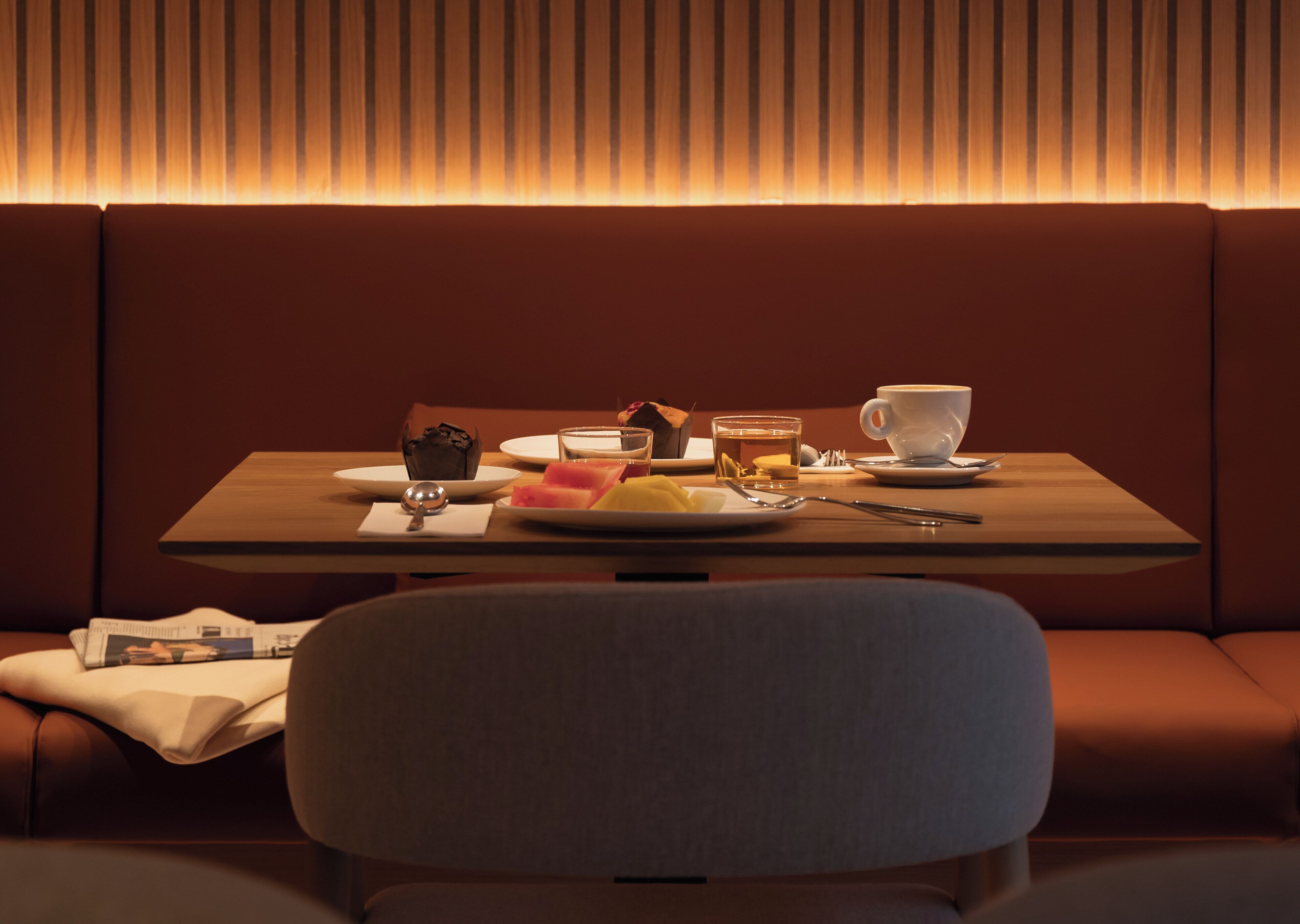 Un rincón acogedor con una mesa preparada para comer, con platos, una taza y un vaso.