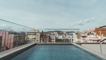 Una piscina al aire libre, sillones reclinables de piscina