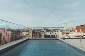 A rooftop swimming pool with a cityscape view.