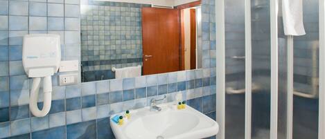 Un baño con lavamanos, espejo y ducha.