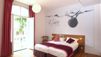 Une chambre à coucher avec un lit, une peinture murale, une fenêtre avec des rideaux et un plancher en bois.
