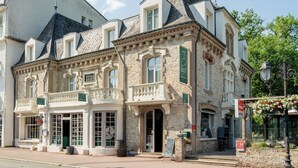 Ein historisches Gebäude mit einer Steinfassade, zahlreichen Fenstern und einem Balkon.