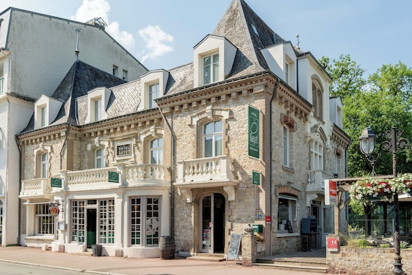 A historic building with a stone facade, multiple windows, and a balcony. - The Originals Boutique, Hôtel Ô Gayot (Bagnoles-de-l'Orne)