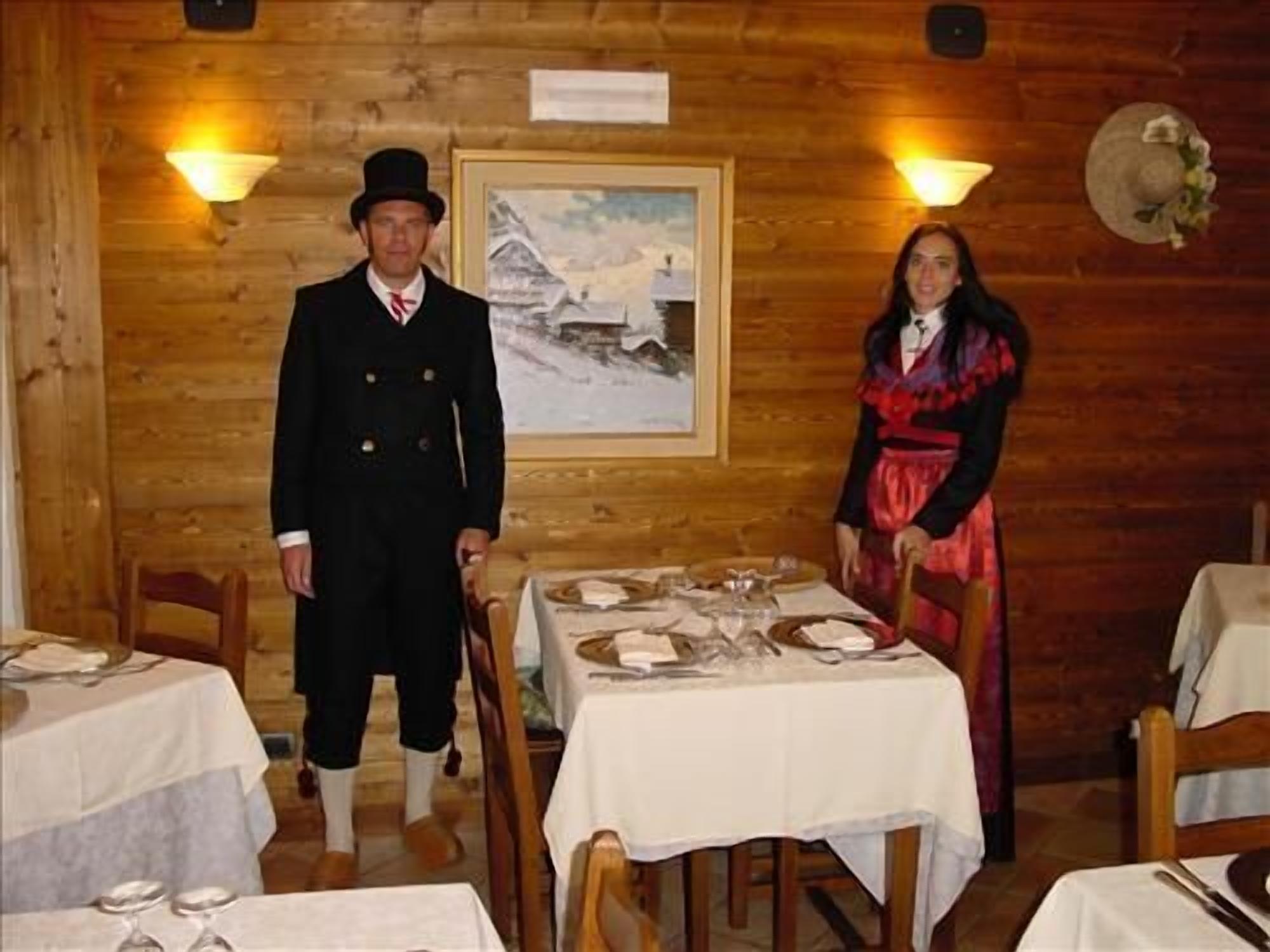 Un interior de madera con mesas dispuestas para comer, un cuadro en la pared y un sombrero colgado en la pared.