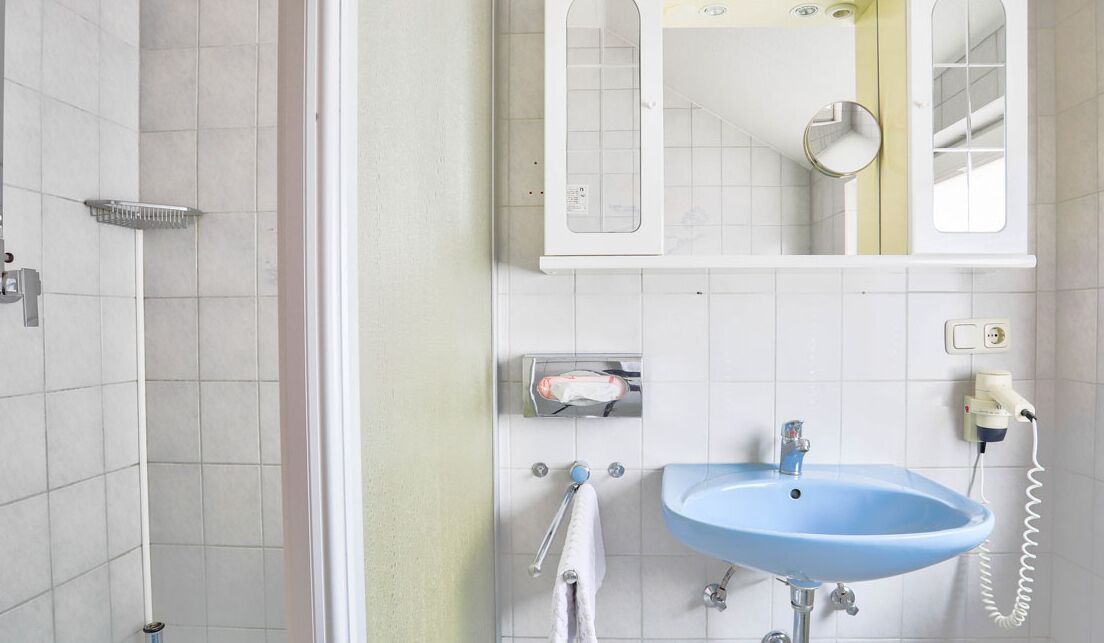 A bathroom with a shower, a sink, and a mirror.