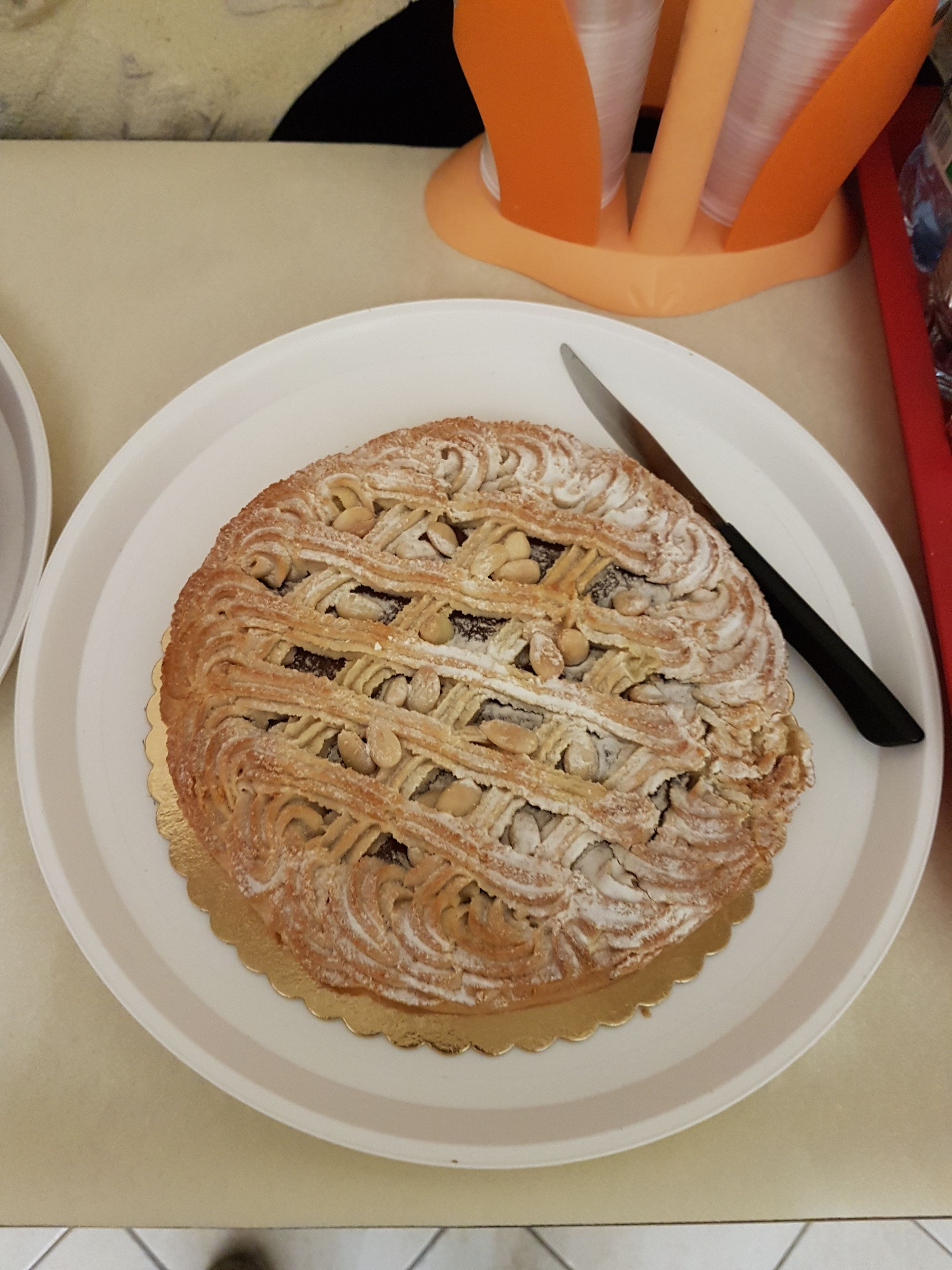 A round cake with a lattice top on a white plate, placed on a table.