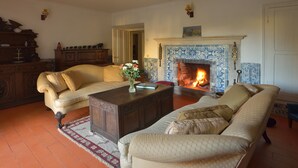 A traditional living room with a fireplace, two sofas, a coffee table, and a wooden cabinet. - Quinta do Scoto (Sintra)