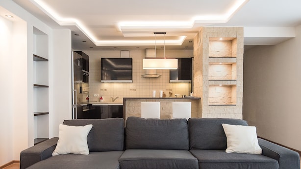 A modern living room with a sectional sofa, a coffee table, and a kitchen area in the background. - Senator Warsaw Apartments (Warsaw)