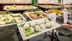 Un bufé con diversos platos, incluyendo huevos, carne y ensaladas.