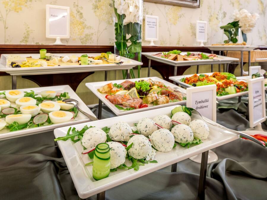 Un bufé con diversos platos, incluyendo huevos, carne y ensaladas.