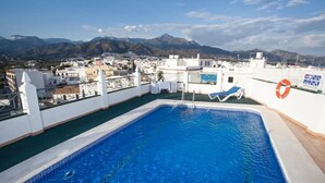 A rooftop pool with a clear view of mountains in the background. - Hotel Bajamar (Nerja)