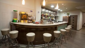 A bar area with stools, a counter, and various bottles and glasses. - Hotel Bajamar (Nerja)