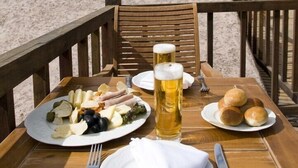 A table set with a meal, beer, and a view of mountains. - Marques de Tojo Hotel (Purmamarca)