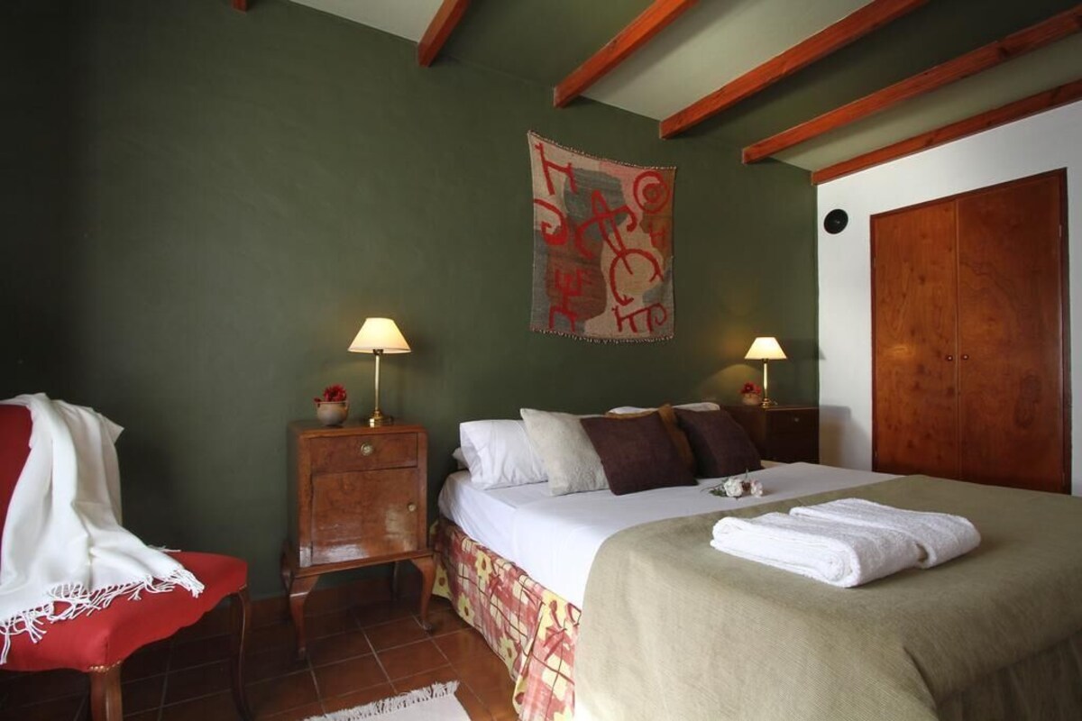 Una camera da letto con un letto, due comodini, un armadio in legno e un arazzo a parete.