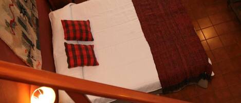 Un dormitorio con cama, dos sillas, una ventana y una escalera.