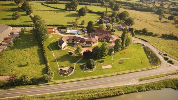 An aerial view of a large estate with a main house, swimming pool, and surrounding green fields. - Delfotel (Hautefond)