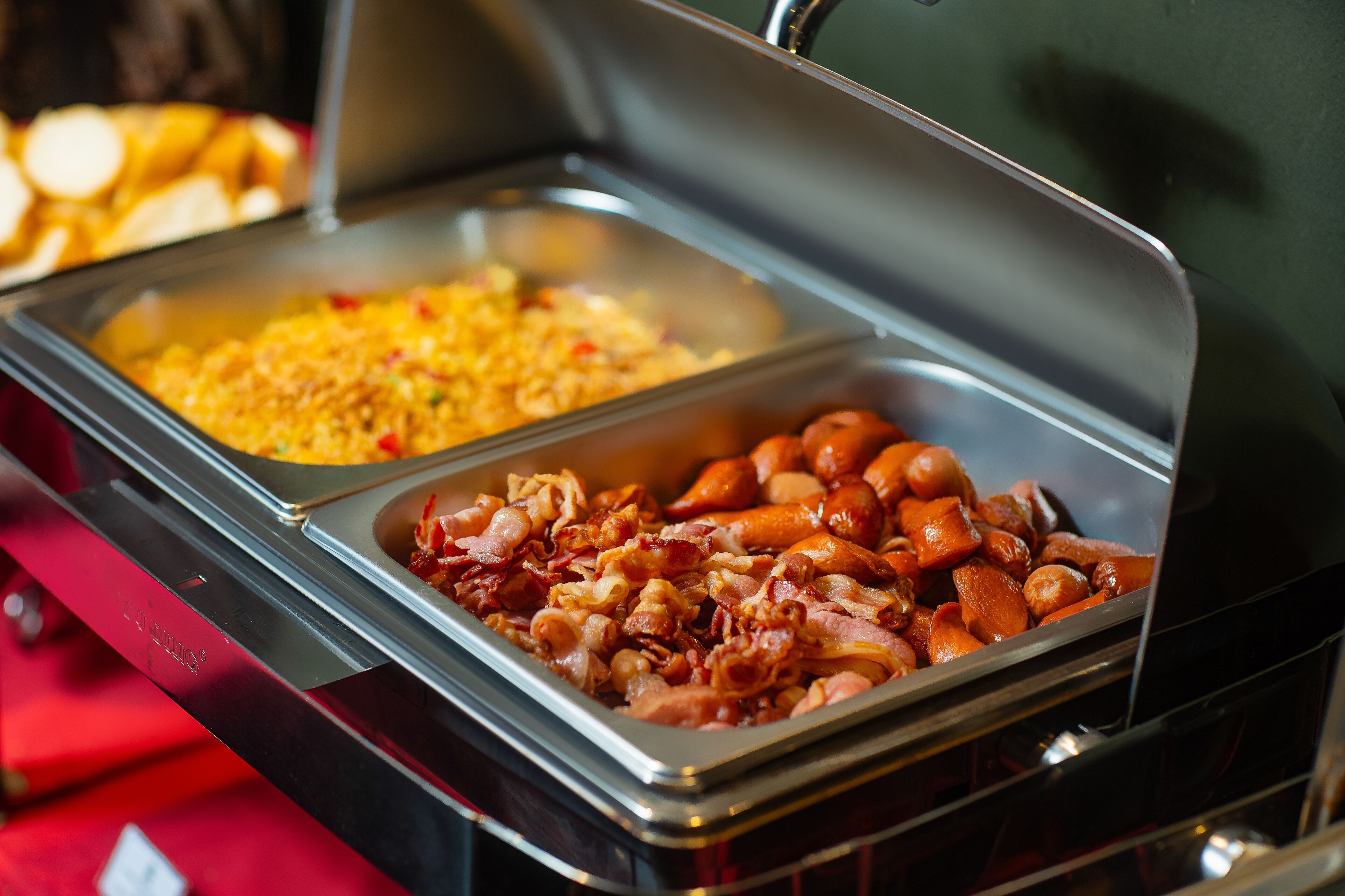 A buffet with various food items including meats and a casserole dish.