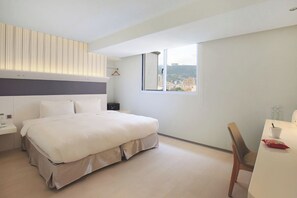 A modern hotel room with a large bed, a desk, a chair, a window with a city view, and a hanging light fixture. - Dandy Hotel Tianmu Branch (Taipei)