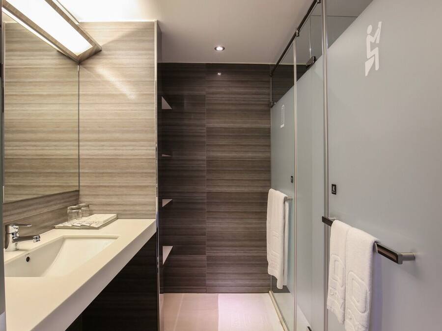 Ein modernes Badezimmer mit zwei Waschbecken, einem Spiegel und einer Duschkabine.