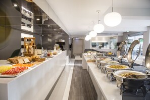 Un moderno montaje tipo buffet con diferentes estaciones de comida y una zona de servicio central.