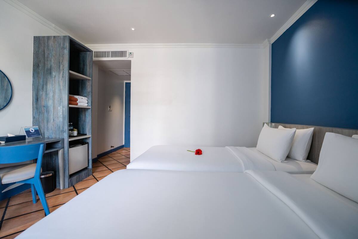 A hotel room with a bed, a desk, and a wardrobe.