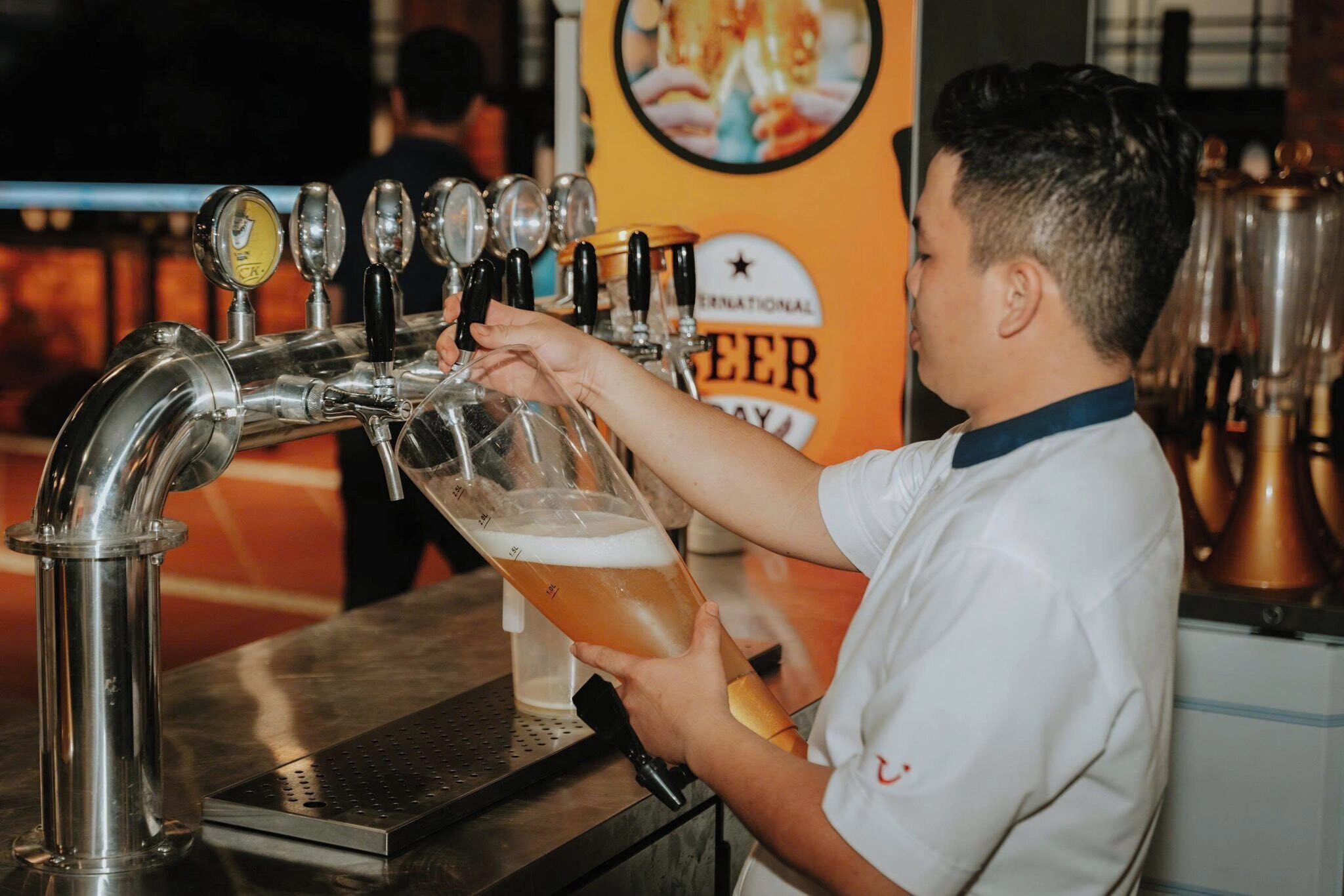 Una persona sirviendo cerveza de un grifo a una jarra.