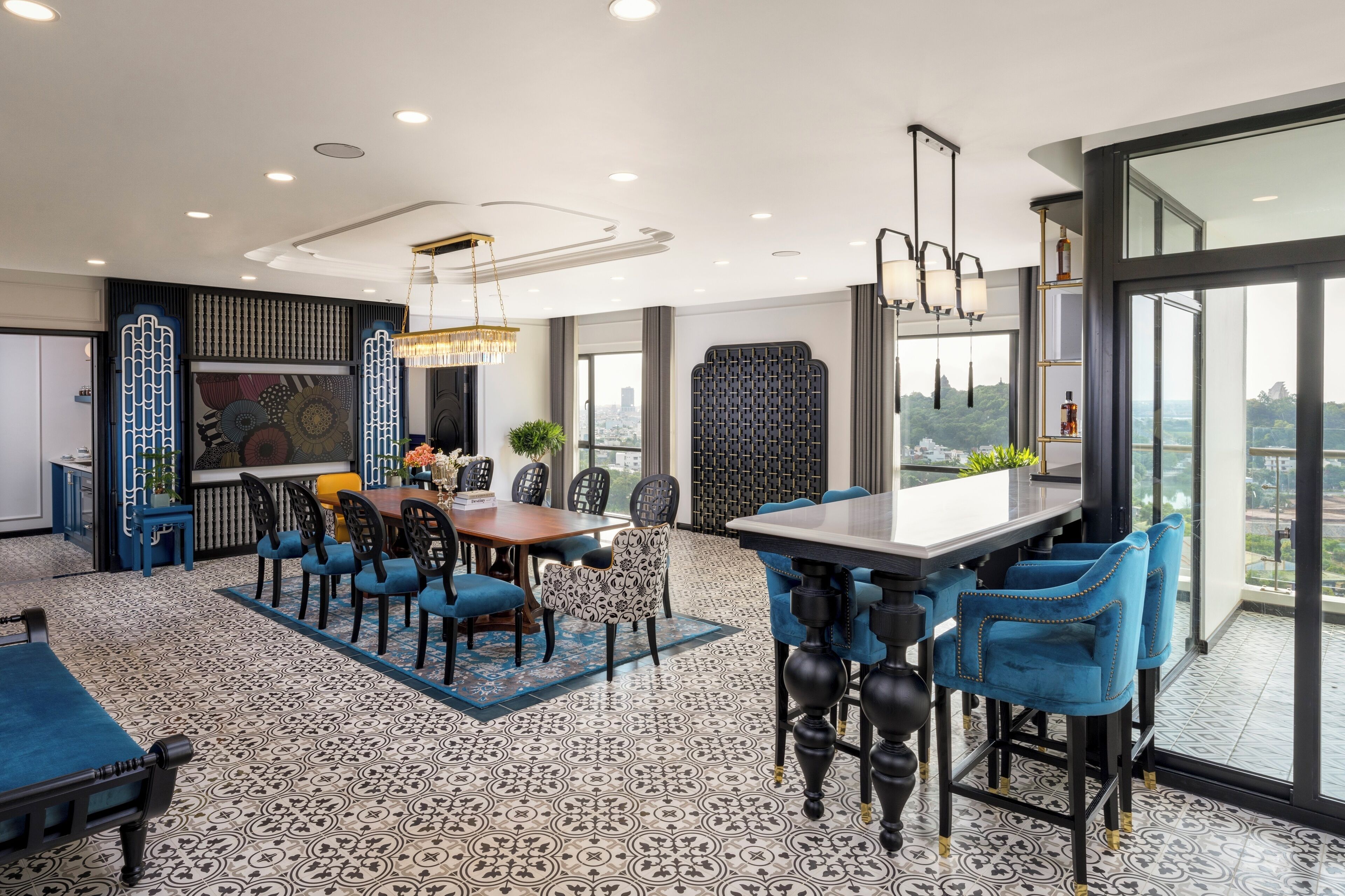 A modern dining area with a large table, blue upholstered chairs, and patterned flooring.