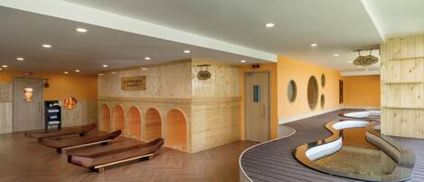 A spa area with wooden benches, a curved hot tub, and a reception desk.